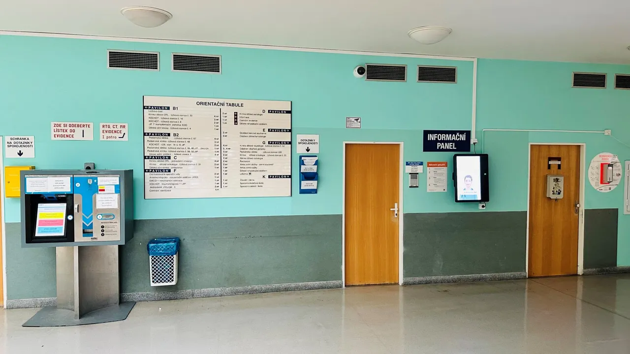 Navigační terminál aReception na zdi vedle orientační tabule pavilonů v Dětské nemocnici Brno