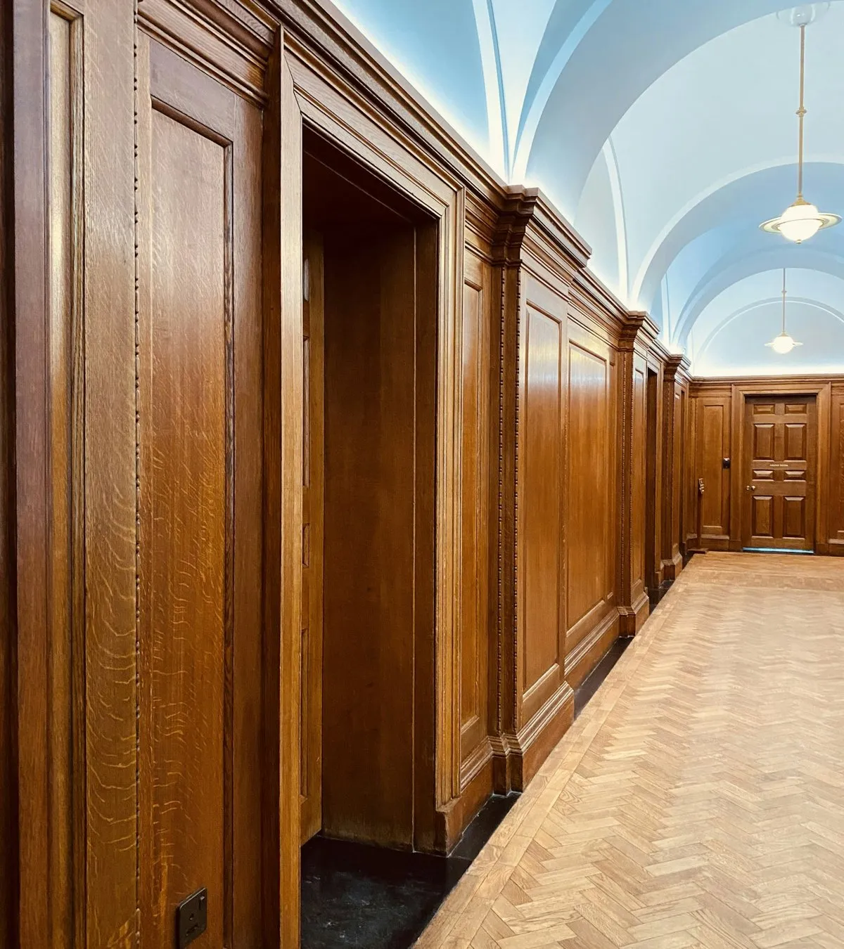 Town hall corridor with wood paneling and a row of office doors