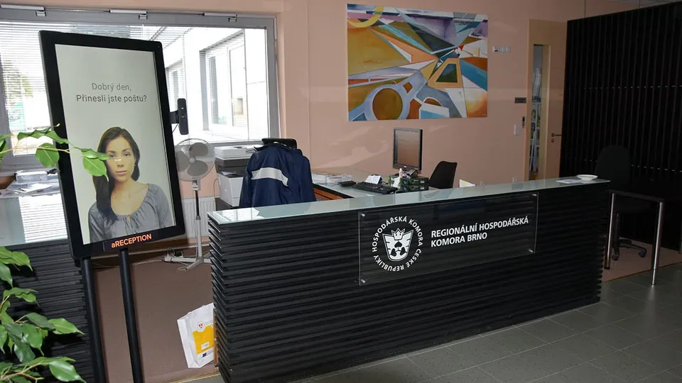 Recepce Regionální hospodářské komory Brno s terminálem aReception u okna a pultem s logem komory