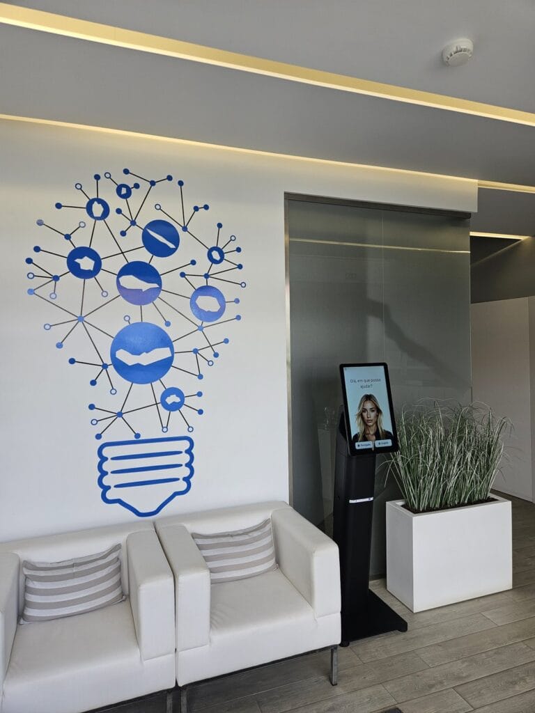 Digital receptionist kiosk in the CEmpA lobby next to the Azores light bulb wall art